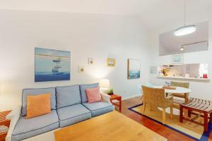 ein Wohnzimmer mit einem blauen Sofa und einem Tisch in der Unterkunft Ocean Mandevilla in Brewster