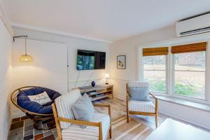 a living room with two chairs and a tv at Sea House in Chatham
