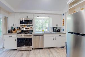 a kitchen with white cabinets and stainless steel appliances at Sea House in Chatham