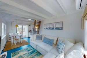 a living room with a white couch and a table at Cottage by the Bay in Pocasset