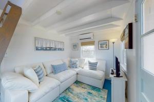 a living room with a white couch and a tv at Cottage by the Bay in Pocasset
