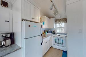 a kitchen with white cabinets and a refrigerator at Cottage by the Bay in Pocasset +11 photos