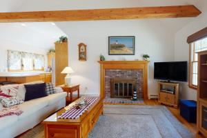 a living room with a couch and a fireplace at The Tranquil Heron Cottage in Eastham +27 photos