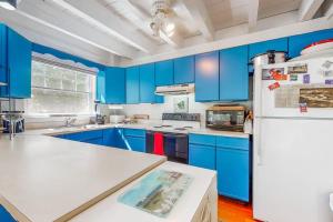 eine Küche mit blauen Schränken und einem weißen Kühlschrank in der Unterkunft Martha's Hideaway in Edgartown