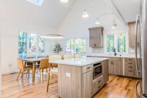 a kitchen and dining room with a table and chairs at Peace Among the Pines in Wellfleet +23 photos