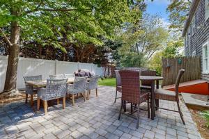 a patio with chairs and tables and a fence at Strawberry Hill Haven in Hyannis