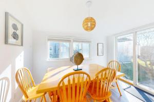 a dining room with a wooden table and chairs at Swift Beach House in Wareham