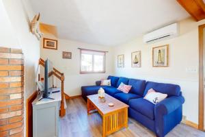 a living room with a blue couch and a tv at Swift Beach House in Wareham