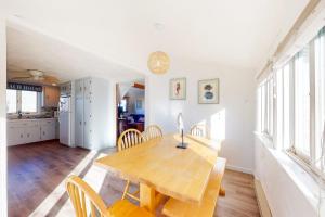 a kitchen and dining room with a wooden table and chairs at Swift Beach House in Wareham +25 photos