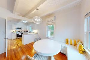 a white room with a white table and a kitchen at Golden Slumbers in Bourne