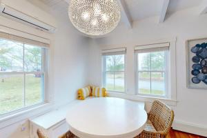 a white dining room with a white table and windows at Golden Slumbers in Bourne
