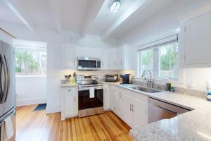 a white kitchen with white cabinets and a sink at Golden Slumbers in Bourne