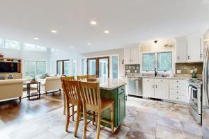 a kitchen with white cabinets and a table and chairs at Bird's Paradise in Oak Bluffs