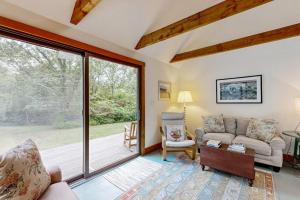 a living room with a couch and a large window at Chilmark Guest House in Chilmark