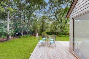 a patio with a table and chairs on a deck at Chilmark Guest House in Chilmark