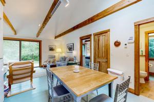 a kitchen and living room with a wooden table and chairs at Chilmark Guest House in Chilmark +17 photos