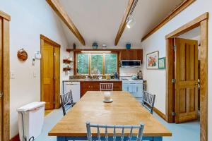 a kitchen with a wooden table and chairs in it at Chilmark Guest House in Chilmark