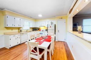 a kitchen with a table and chairs and a refrigerator at Stop And Relax in Ocean Pines