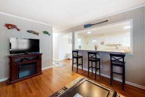 a living room with a kitchen and a bar with stools at Stop And Relax in Ocean Pines
