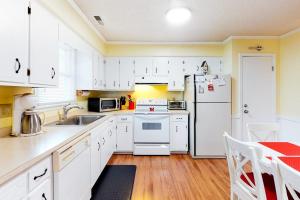 a kitchen with white cabinets and a white refrigerator at Stop And Relax in Ocean Pines +14 photos
