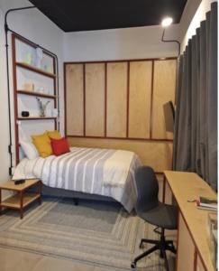 a bedroom with a bed with a desk and a chair at Casa Tabacalera in Mexico City
