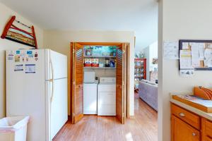 two views of a kitchen with a refrigerator at Dove Lane 8 in Ocean Pines