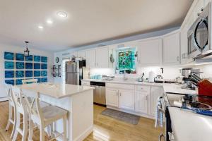 a kitchen with white cabinets and a kitchen island at Bird Street Breeze in Oak Bluffs +20 photos