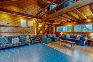 a living room with blue couches and a wooden ceiling at Cozy Island Cabin in Edgartown