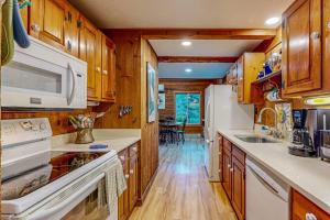 a kitchen with white appliances and wooden cabinets at Cozy Island Cabin in Edgartown
