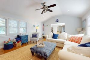 a living room with a white couch and a ceiling fan at Briarcliff Bliss in Barnstable