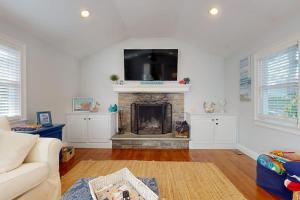 a living room with a fireplace with a flat screen tv at Briarcliff Bliss in Barnstable