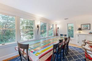 a dining room with a table and chairs and windows at Mermaid's Rest in Centerville