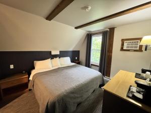 a hotel room with a bed and a window at Lake Ontario Motel & Inn in Newfane