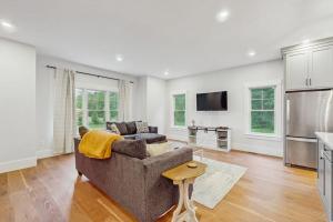 a living room with a couch and a kitchen at Heritage Escape in Mashpee