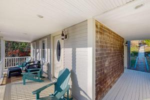 a porch with two blue chairs on a house at Pond View Getaway in Sandwich