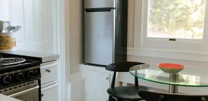 a kitchen with a glass table and a refrigerator at The Duo- Myles & Paul in Provincetown