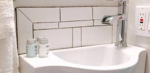 a bathroom sink with a faucet and two bottles on it at The Duo- Myles & Paul in Provincetown