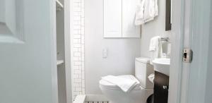 a white bathroom with a toilet and a sink at The Duo- Myles & Paul in Provincetown