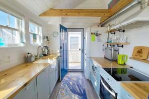 a kitchen with white cabinets and a blue door at Seas The Day in North Truro