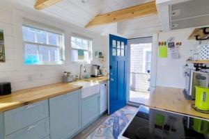 a kitchen with blue cabinets and a blue door at Seas The Day in North Truro
