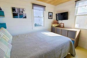 a bedroom with a bed and a flat screen tv at Seas The Day in North Truro +10 photos