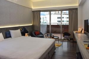 a hotel room with a bed and a balcony at Metro Hotel in Douliu