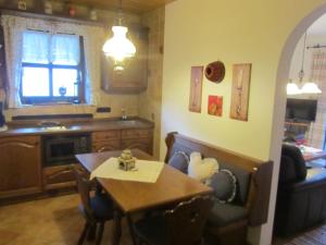 a living room with a table and a kitchen at Landhaus Sailer in Mittenwald