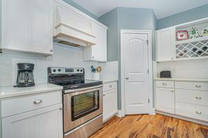 a kitchen with white cabinets and a stove top oven at Thunder Road in Fennville +33 photos
