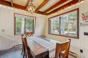 a dining room with a wooden table and two windows at Crystal Chalet in Thompsonville