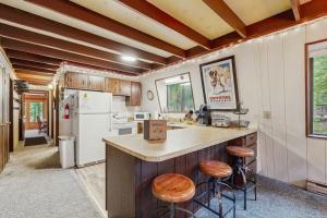 a kitchen with a counter with stools and a refrigerator at Crystal Chalet in Thompsonville +16 photos