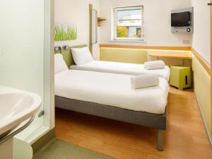 a room with two beds and a sink at ibis budget Sheffield Arena in Sheffield