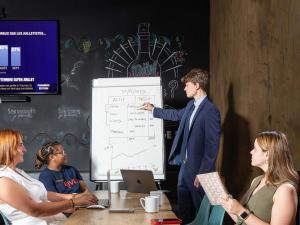 a man giving a presentation to a group of people at ibis Bordeaux Centre Bastide in Bordeaux