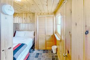 a small bedroom with a bed and a window at Dune Grass Shores in Beulah