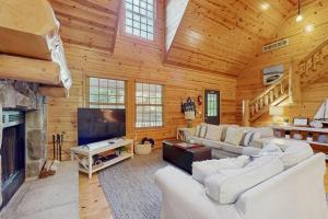 a living room with white furniture and a fireplace at Kingfisher Cove Cabin 19 in Saugatuck